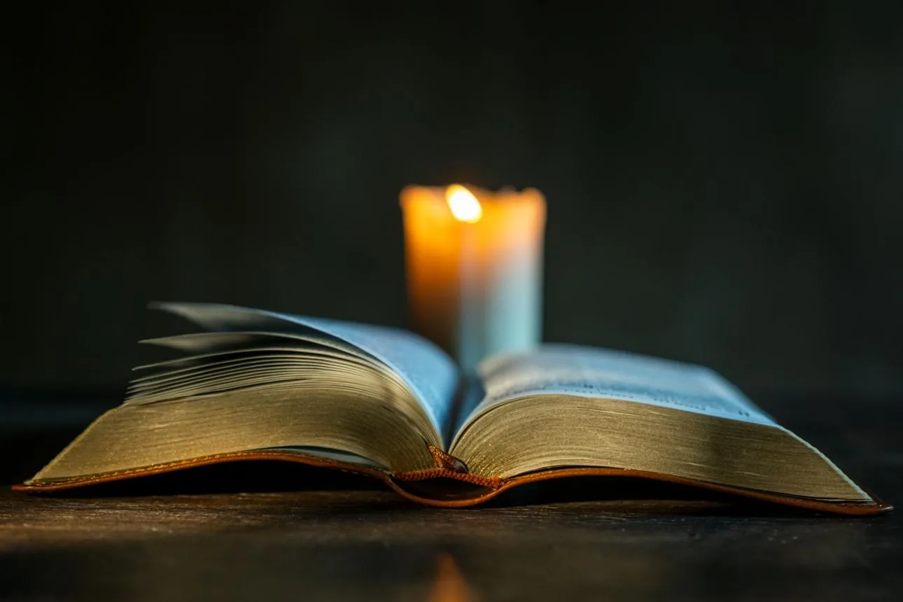 Open Bible beside a candle